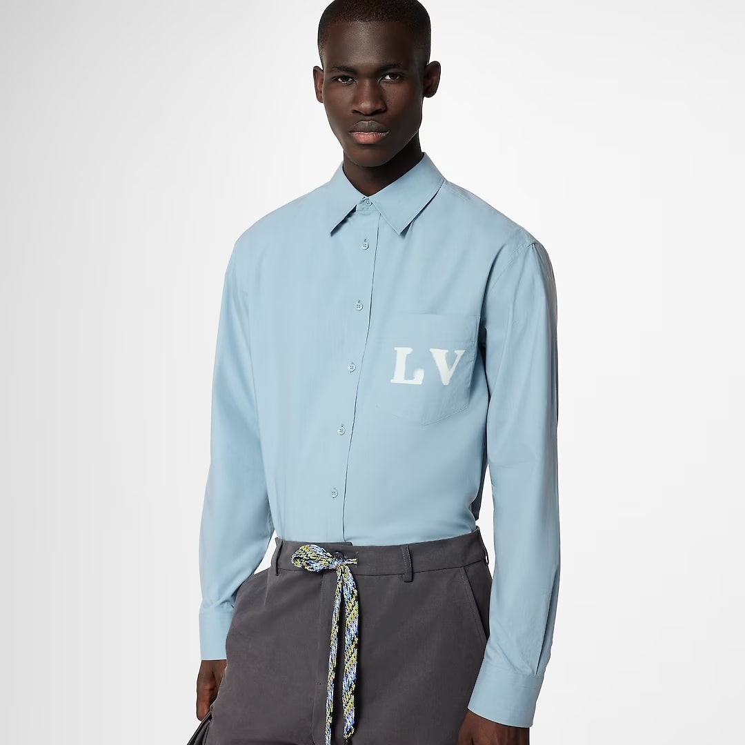 This photo shows a man wearing a light blue Louis Vuitton shirt.